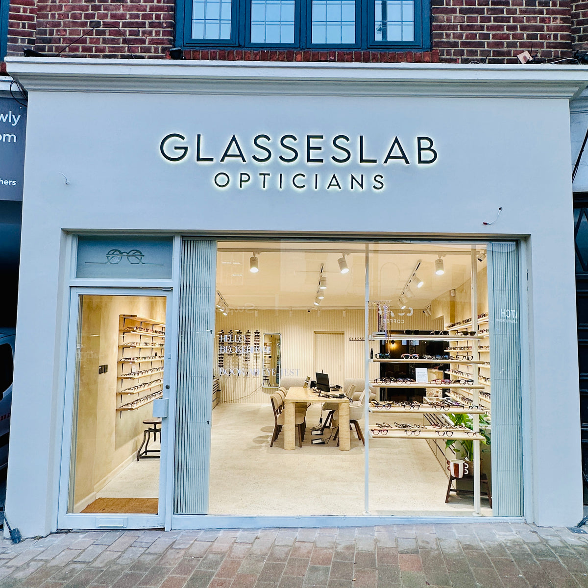White Glasseslab Opticians shopfront with a wide window showing the bright eyewear displays inside.